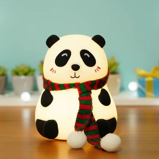 Cute panda night light wearing a red and green scarf, sitting on a wooden table