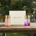 Bellavita perfume gift set with four colorful bottles on wooden table, garden background